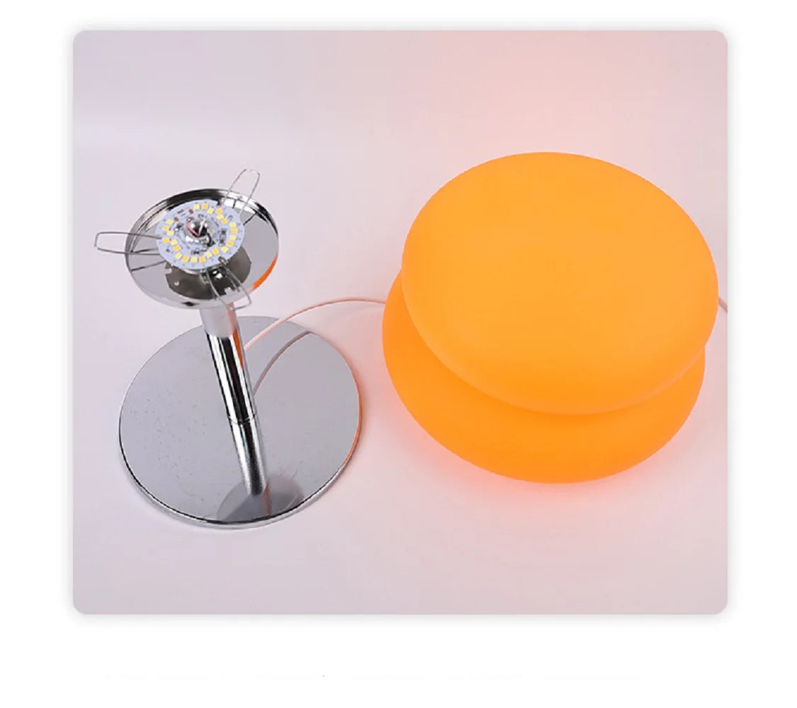 Modern cloud-shaped bedside lamp featuring an orange light and a silver base.