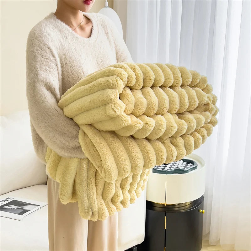 A person is holding a large, fluffy, light yellow fleece blanket with a ribbed texture.