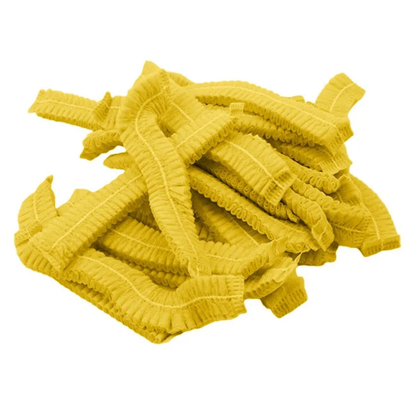A pile of yellow disposable non-woven hair net caps.