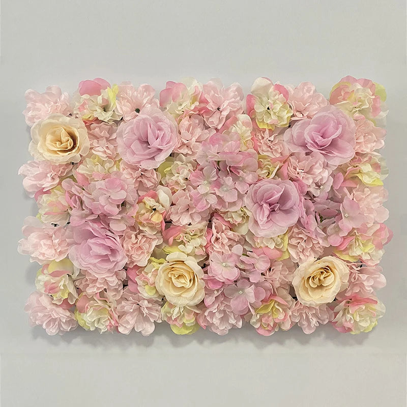 A dense wall panel of pink and cream silk rose flowers for weddings and events.
