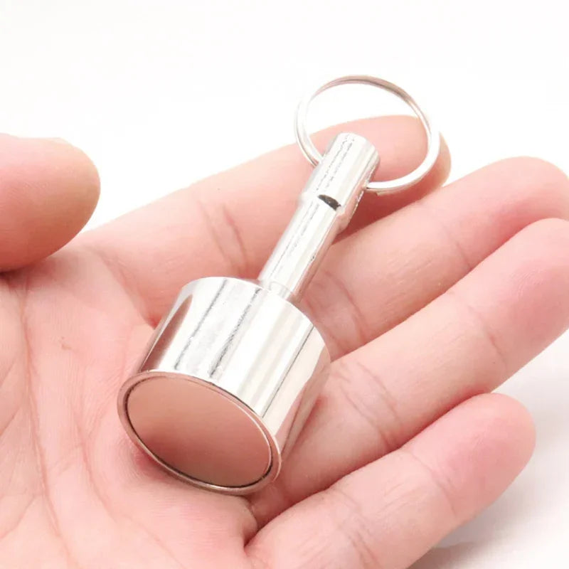 A hand holds a silver neodymium magnet keychain with a detachable clasp.