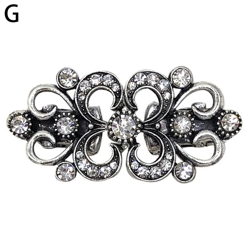 Silver vintage swirl clip featuring small clear stones used to fasten sweaters and shawls