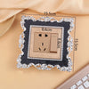 A square switch cover frame with a rose pattern border and brass accents, shown on a light background.