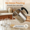 Stainless steel wax melting pitcher pouring liquid into glasses on a countertop