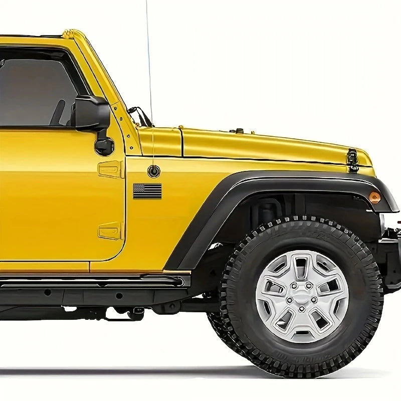 A yellow Jeep Wrangler with a matte black flag emblem set on the front fender.
