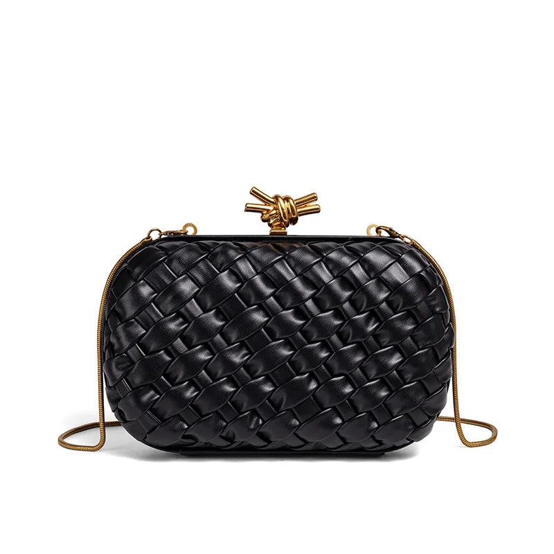 A black handwoven woven clutch bag with a gold chain strap.