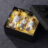 A black box contains three handcrafted astronaut figurine resin spaceman desk decor figures surrounded by yellow wispy materi