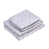 A stack of silver quilted ironing mats for wrinkle removal.