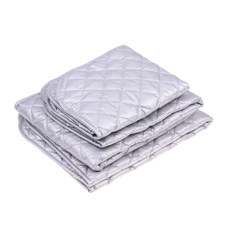 A stack of silver quilted ironing mats for wrinkle removal.
