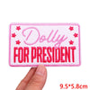 Pink embroidered iron-on patch set with the text Dolly for President
