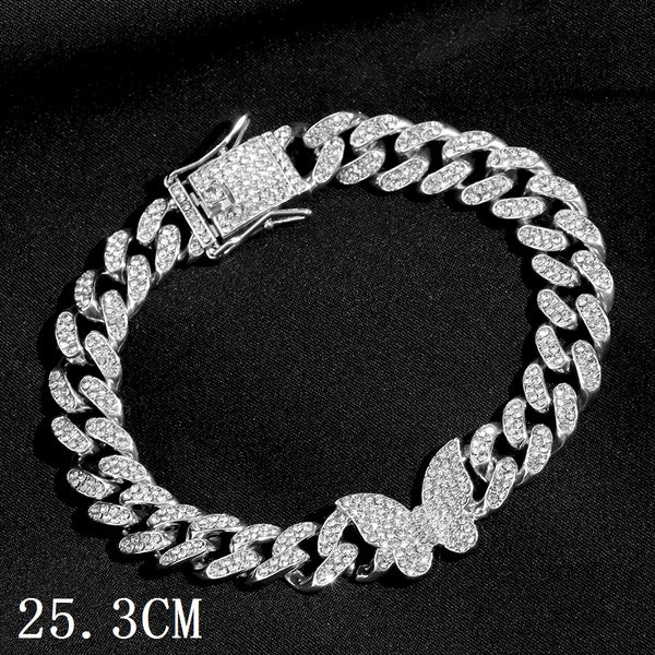 Bracelet Cuban en argent taillé avec pendentif papillon sur fond noir.