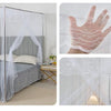 A princess-style lace canopy mosquito net draped over a bed and a hand showing the delicate lace pattern.