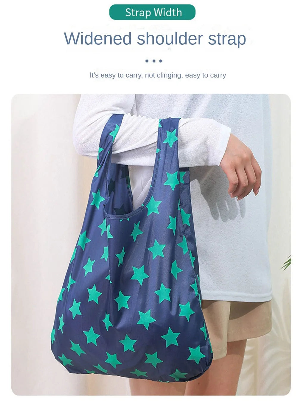 A dark blue shopping bag with a widened shoulder strap featuring green stars, being carried by a person.