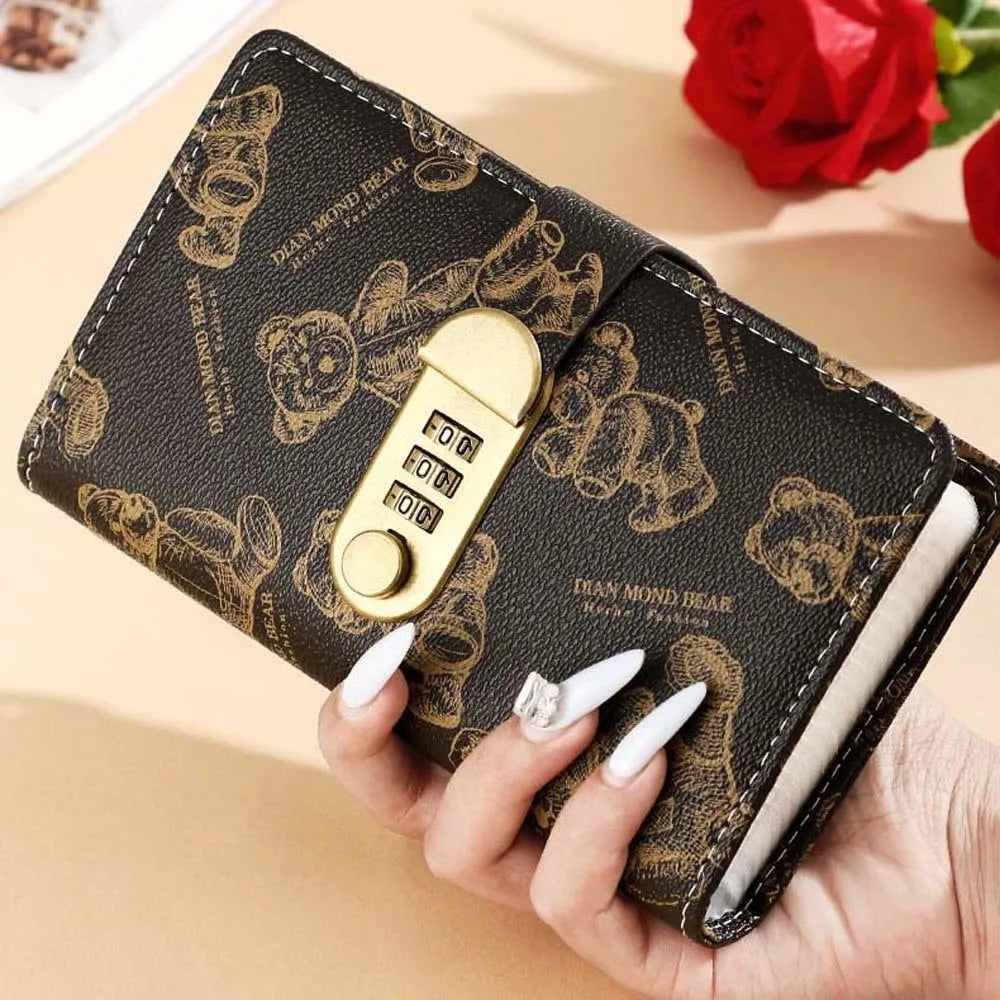 A brown leather wallet featuring a cartoon bear design and a gold lock, held by a hand.