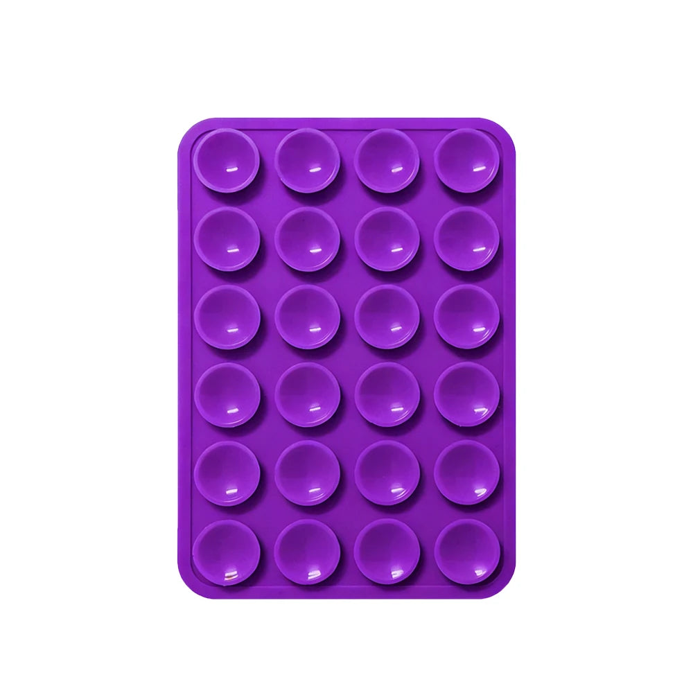 A purple silicone suction pad with multiple circular indentations for phone mounts.