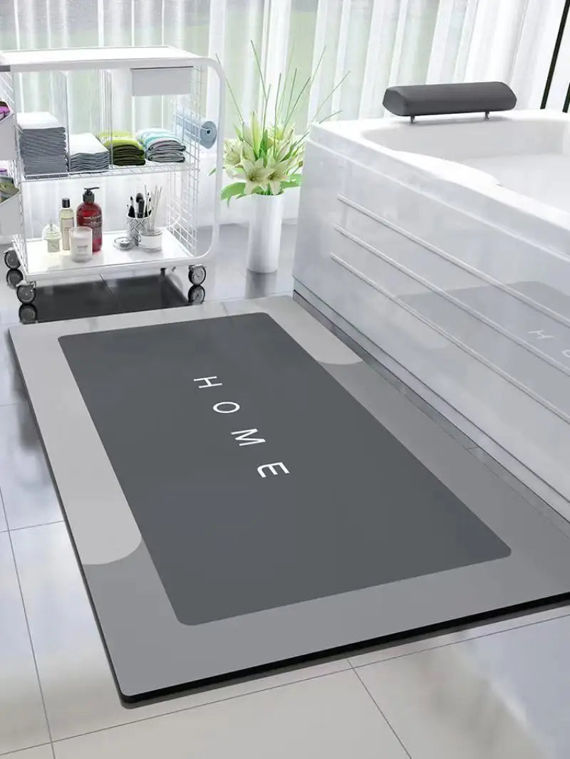 A modern bathroom featuring a large white bathtub and a rectangular mat with the word HOME engraved on it.