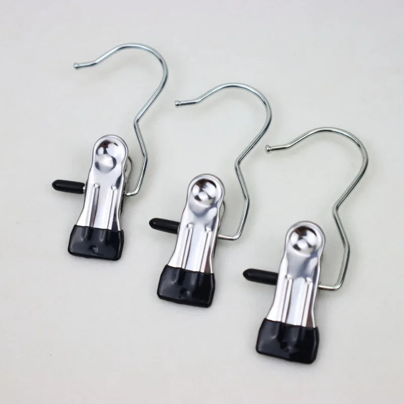 Three stainless steel clothespins with hooks for space-saving laundry drying
