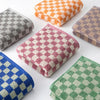 A set of plaid cotton bath towels in various colors including orange, gray, pink, and green.
