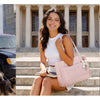 Three young women posing outdoors and near a building, holding or standing with a multi-functional boxy tote bag.
