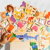 A child is assembling a wooden animal alphabet puzzle for early learning.