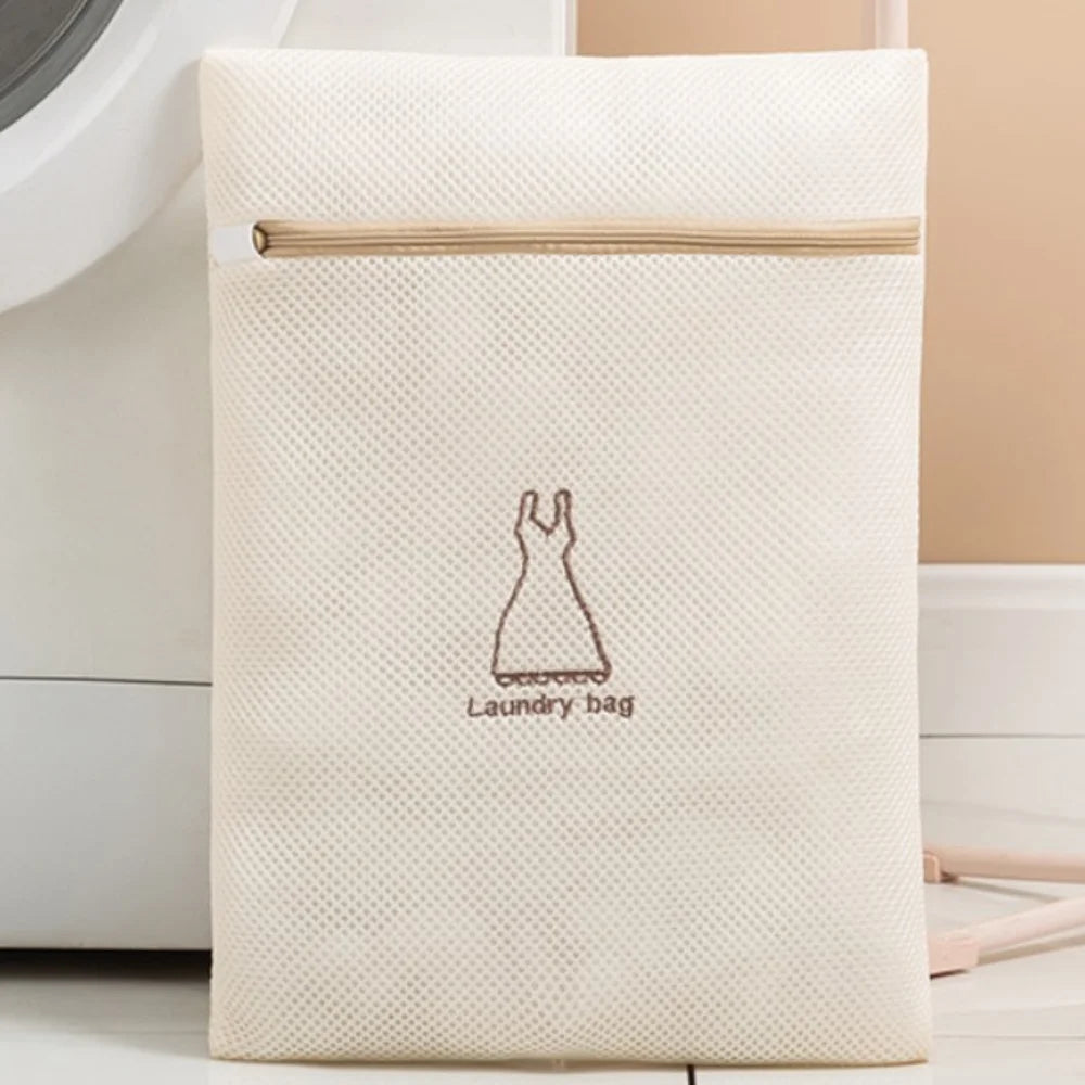 Beige wiederverschließbare Wäschetasche mit hellem Holzrand und einer Zeichnung eines Kleides.