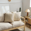 A set of two beige woven linen pillow covers displayed on a light wood sofa.
