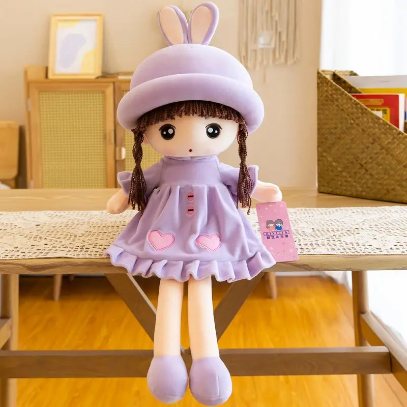 A purple rabbit fairy plush doll with long ears and braided hair sitting on a wooden table.