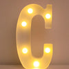 A glowing letter C made of LED lights used as a night light or party decor.
