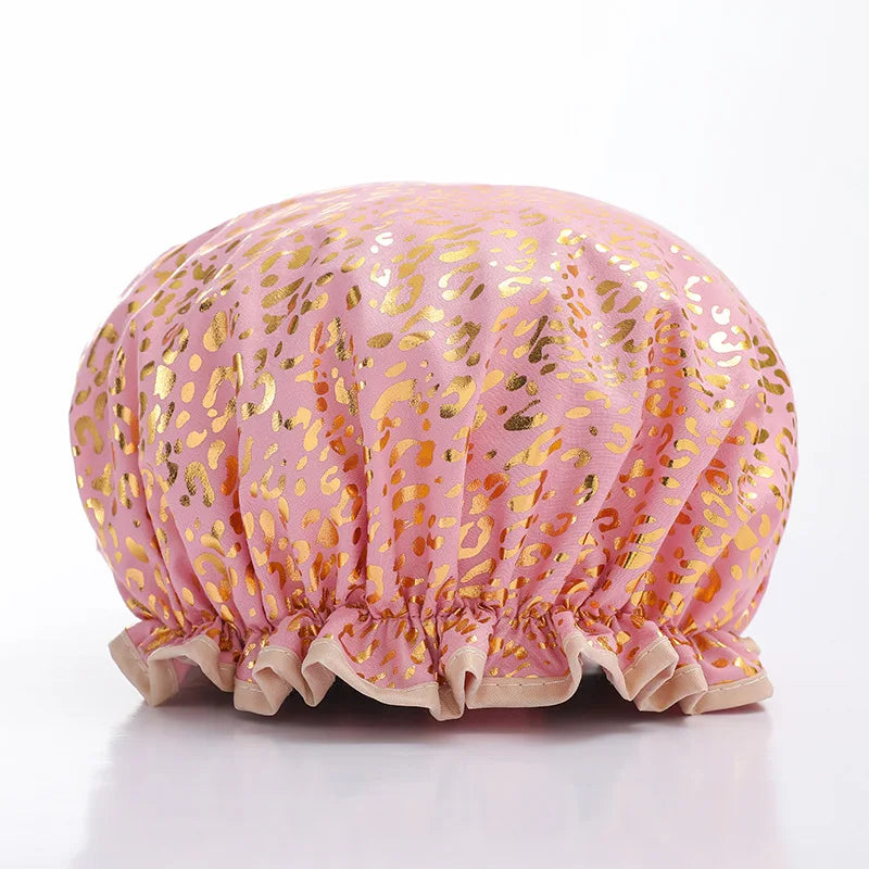 A reusable elastic shower cap for women in pink fabric with gold leopard print.