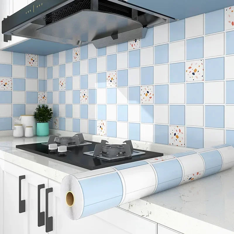 A kitchen splashback featuring blue and white tiled wallpaper with orange accents, above a countertop.