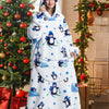 A woman wearing an oversized white and blue penguin hoodie blanket in a bright indoor setting.