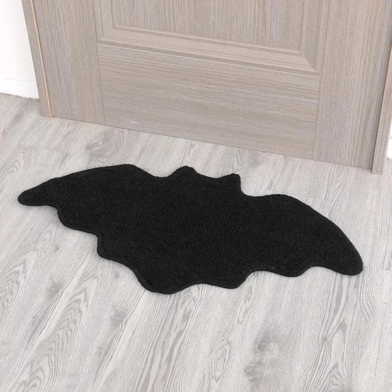 Black decorative rug shaped like a Halloween spider web with a ghost design placed on a light wood floor.