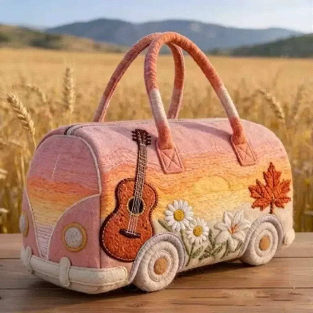 A pink quilted travel duffle bag with orange handles and 3D stitching resting on a wooden surface.