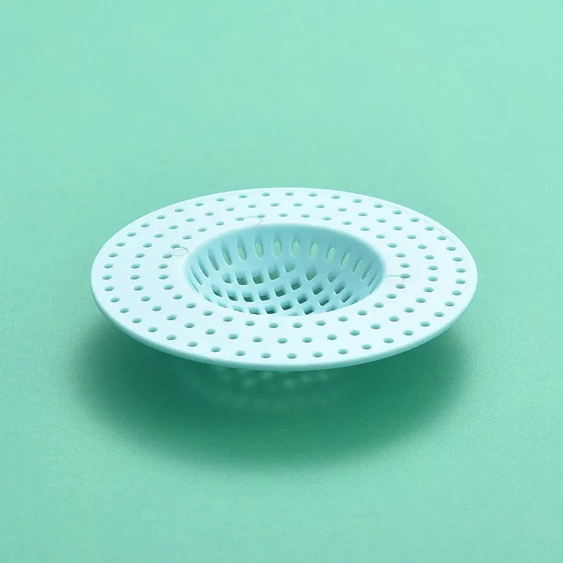 A white silicone sink drain filter strainer with a perforated design is shown against a light green background.