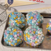 A collection of colorful, squishy sensory stress balls in various pastel shades resting on a metal tray.