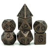 A set of seven metal polyhedral dice with a dragon font design arranged in a pyramid shape.