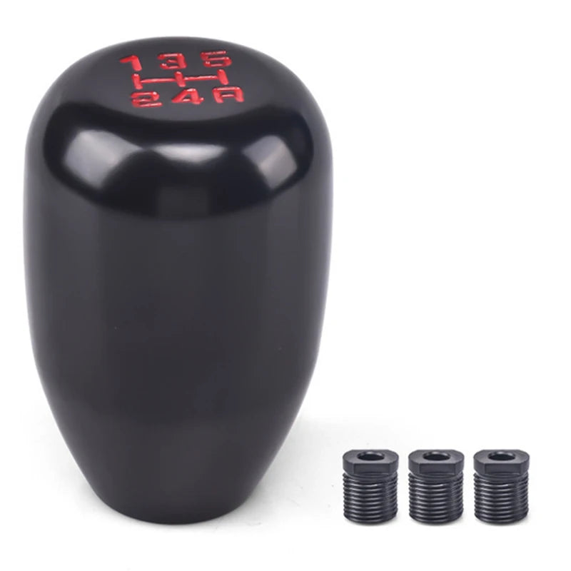 Black gear shift knob with red markings and three adapter pieces