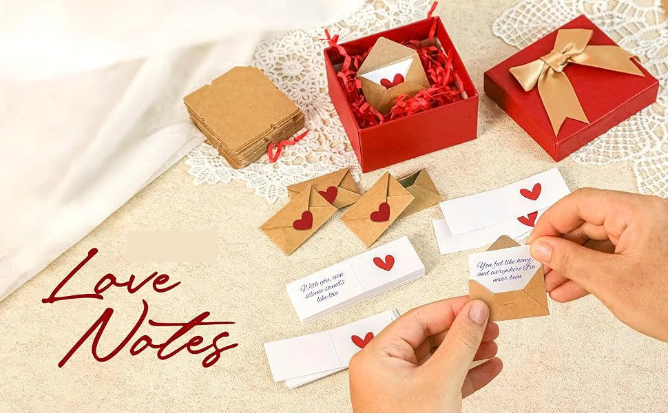 A set of red and brown stationery including envelopes and note cards for love notes is displayed on a light fabric surface.
