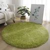 A round, bright green shaggy rug placed on a light wood floor in a living room setting.