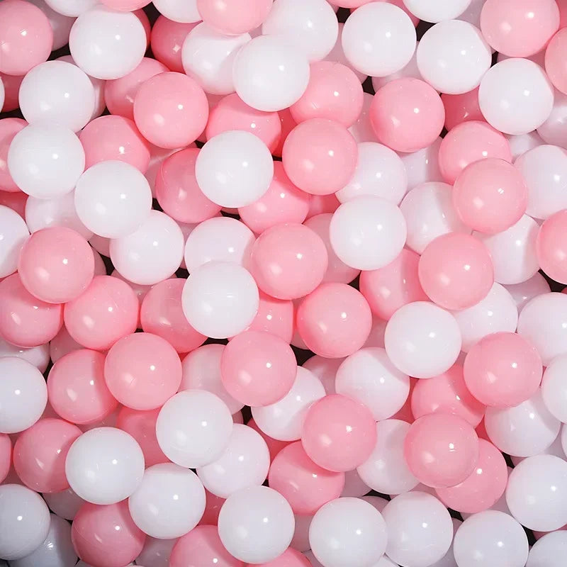 A close-up view of a large pack of pink and white colorful ball pit balls for toddlers.