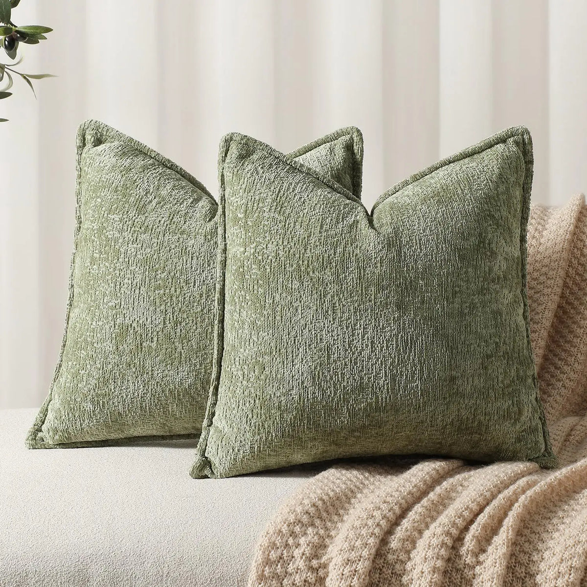 A moss green chenille decorative cushion cover square throw pillow resting on a beige fabric surface.