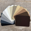 A collection of iron-on fabric patches in various neutral and earth tones arranged in a fan shape.
