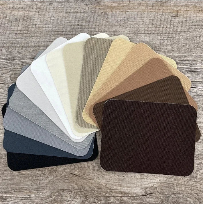 A collection of iron-on fabric patches in various neutral and earth tones arranged in a fan shape.