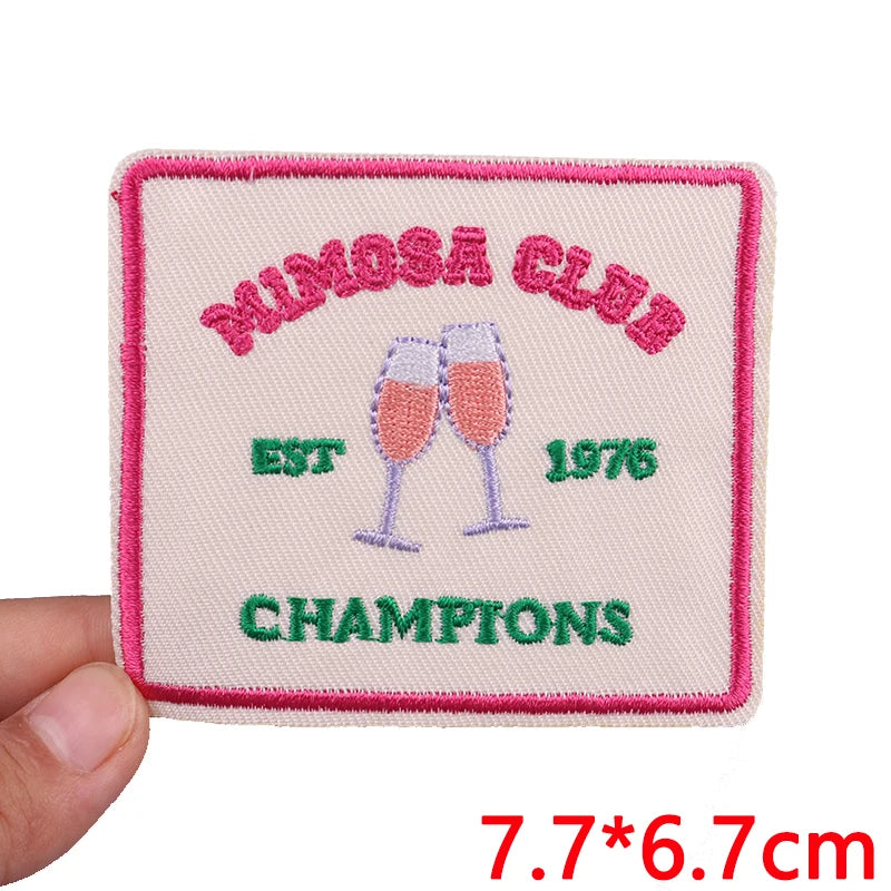 Pink embroidered patch for a Mimosa Club championship, featuring champagne glasses and the year 1976.