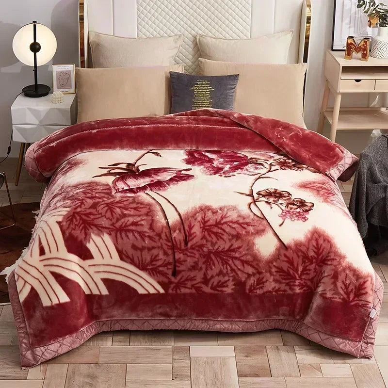 A deep red and cream weighted plush blanket with a floral pattern displayed on a bed.