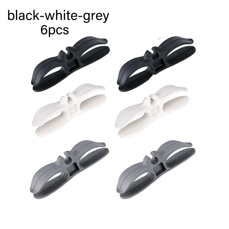 Six black and white-grey cord organizers or wire winders for tidy cable management.