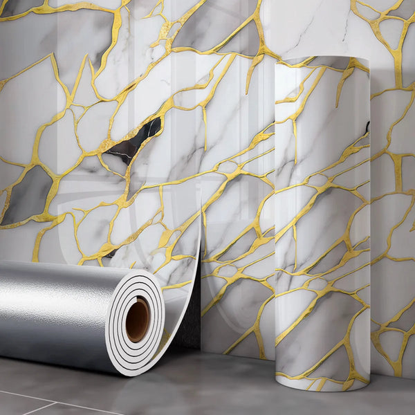 Roll of silver peel and stick wallpaper featuring a marble effect with gold veining on a wall.