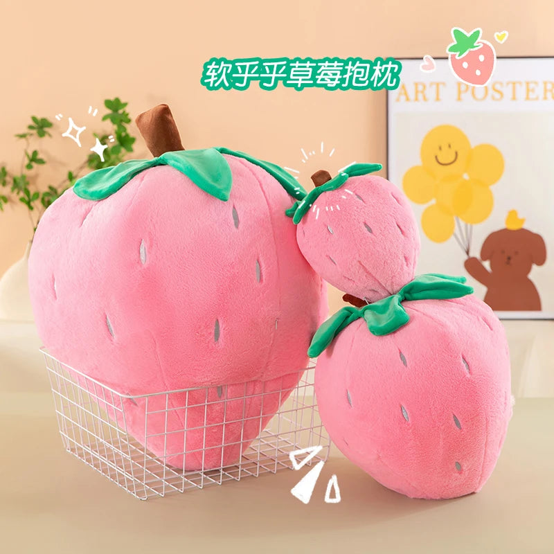 Pink strawberry plush toy with green leaves displayed in a wire basket.