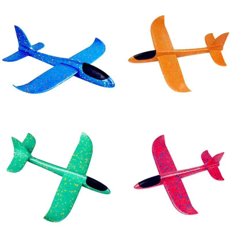 Four foam glider planes in blue, orange, green, and red colors shown from the side.