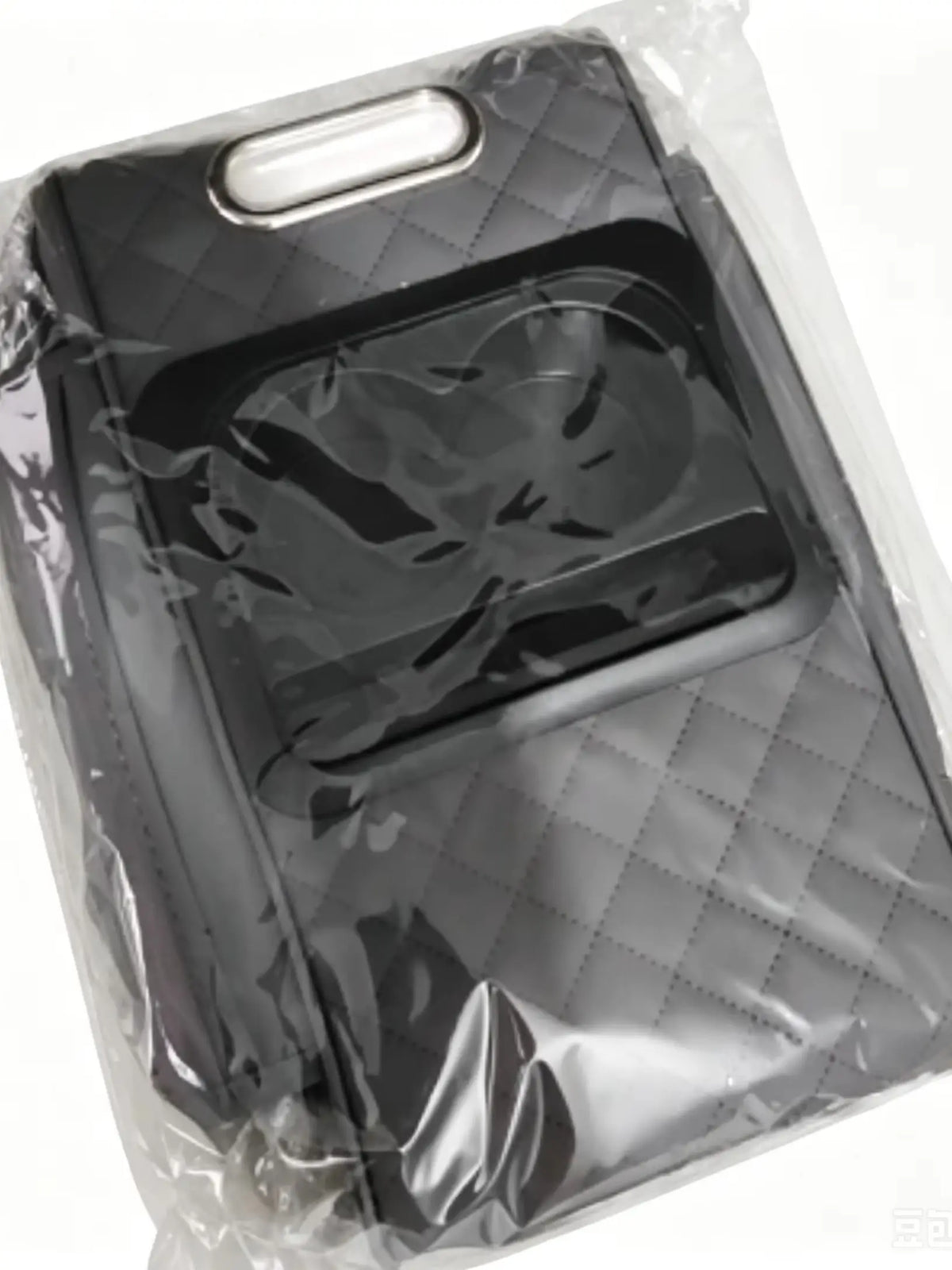 A black car center console armrest cushion with a cup holder and storage pockets is visible inside clear plastic packaging.